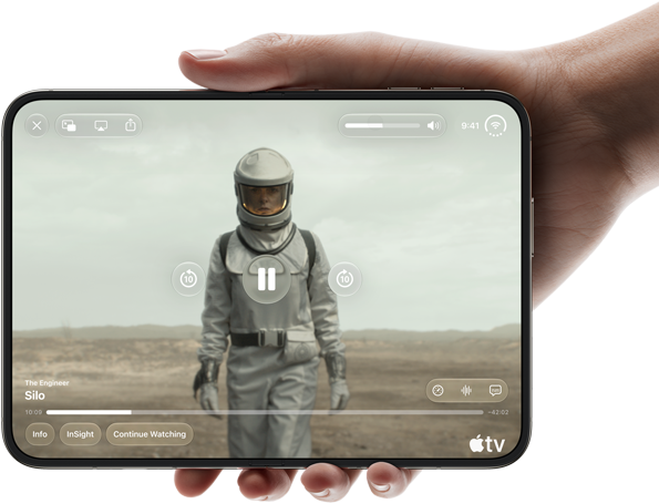 iPhone Duo, държан с една ръка, отворен в хоризонтална ориентация, напълно разгънат, вътрешният екран показва Apple TV сериала „Silo“