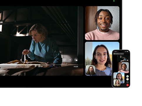 Mac et iPhone : écran de Mac en affichage Split View, SharePlay activé, une série Apple TV joue à gauche, des tuiles FaceTime à droite montrant trois personnes, un iPhone est fixé à côté du Mac et utilisé comme caméra de continuité