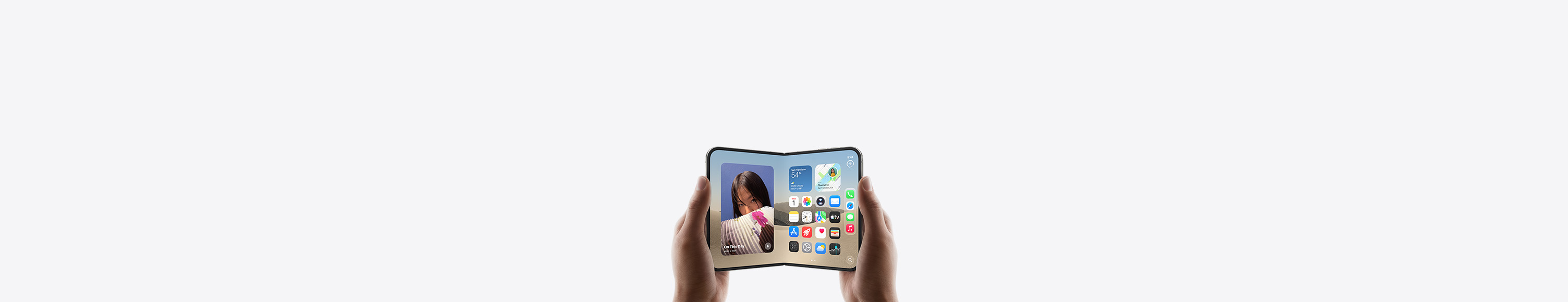 iPhone Duo, held by two hands in landscape orientation, unfolded, interior display features Home Screen.