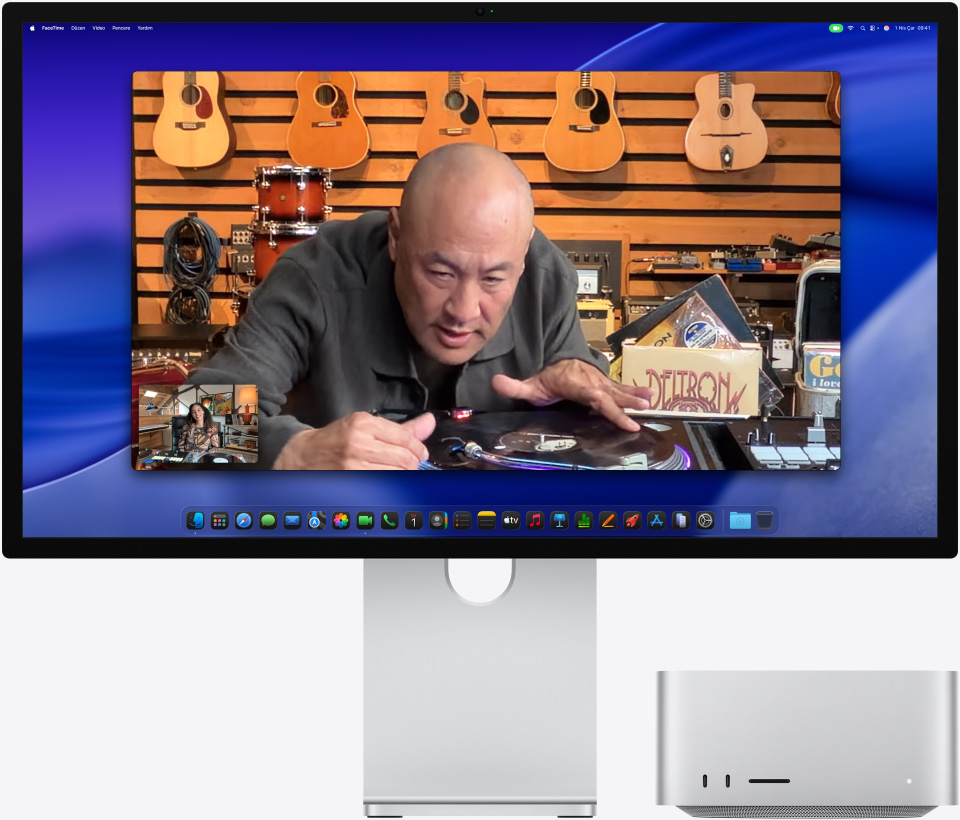 Yanında Mac Studio bulunan bir Studio Display XDR’da görüntülü arama yapan bir kişi, müzik mağazasında bir pikabı yakından inceliyor