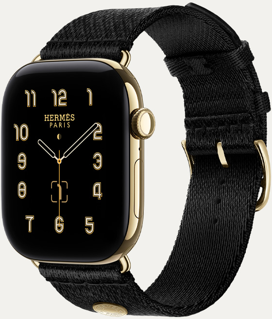 Apple Watch Hermès Series 12, analoges Clou de Selle Zifferblatt (Stunden-, Minuten- und Sekundenzeiger, Komplikationen: Mondphase, Datum), Titangehäuse, Farbe Brillantgold, rechte Seitenansicht, Digital Crown, Seitentaste, kombiniert mit Satin Clou de Selle Armband in Noir, weiches, schwarzes satiniertes Gewebe mit Metallelementen in Brillantgold, passend zum Gehäuse der Watch