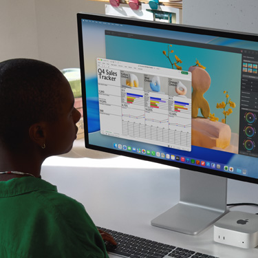 Çalışma masasında oturan ve Mac’te bir Excel hesap tablosu üzerinde çalışan bir kadın. Excel hesap tablosunda 4. çeyrek satış verileri bulunuyor. Excel hesap tablosu penceresinin arkasında bir Pixelmator Pro penceresi görülüyor.