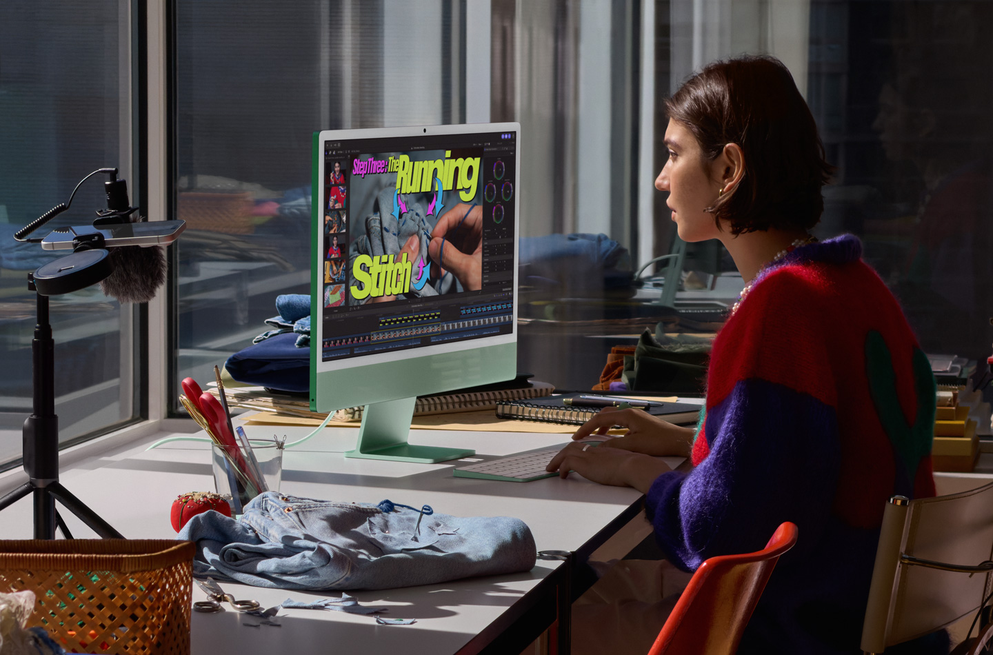Một người đang làm việc tại bàn với iMac màu xanh lá, gõ phím trên Magic Keyboard và sử dụng Magic Mouse, xem hướng dẫn may vá