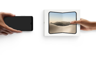スマートフォンを交換する2つの手。左側に箱のないAndroidがあり、右側に箱に入った新しいiPhone Duoがある