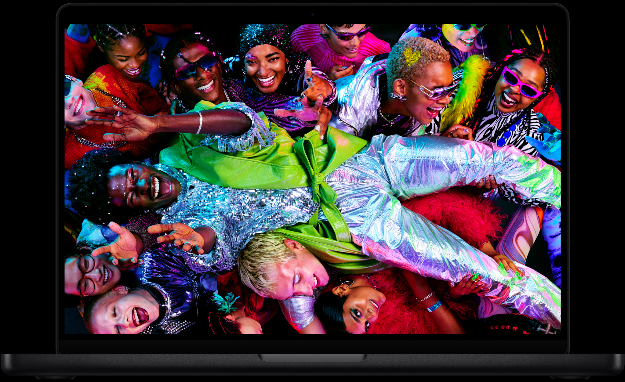 Uma imagem colorida no MacBook Pro mostra uma pessoa passando por cima de uma multidão em uma festa, destacando a tela Liquid Retina XDR vibrante